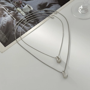 Vue détaillée des colliers à pendentif goutte d'argent avec chaînes serpent et box fines