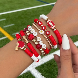 Detail of multi-layered Game Day beaded bracelets with football and helmet charms on turf