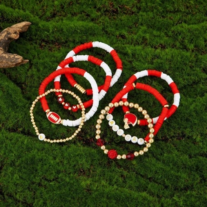 Detail of Game Day beaded bracelets with football charms on green moss background