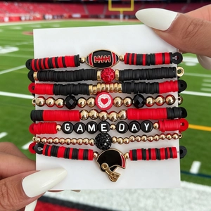 Detail of Game Day bracelets set with red black clay beads and football charms