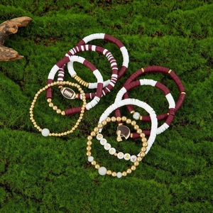 Detail of Game Day stretch bracelets with maroon Heishi beads and football charms