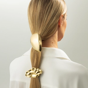 Détail d'un accessoire à cheveux doré géométrique et élastique en métal martelé