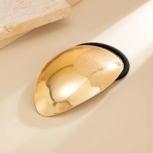 Détail de l'élastique à cheveux géométrique doré avec une finition métal brillante