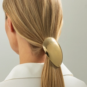 Barrette dorée ovale en métal avec finition miroir polie sur une queue de cheval