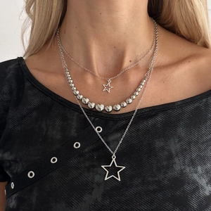 Detailed view of silver-tone three-layer star pendant necklace set with polished beads