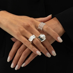 Three-piece silver ring set featuring a pearl open ring and textured geometric bands