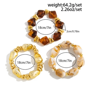 Detailed view of 3-piece beaded bracelet set in amber, gold, and marble resin textures