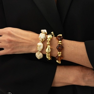 Detail of layered bracelet set featuring marble resin beads and golden metallic accents
