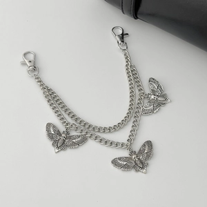 Detail of silver double-layered pants chain featuring gothic moth and skull pendants