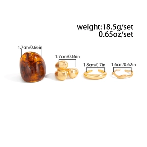 Detailed view of 4-piece gold metal and amber resin rings set with size specifications