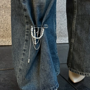 Spilla argentata con nappe, perle e ciondolo a stella su jeans da donna
