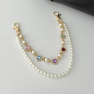 Detail of double-layer chain with white pearls, colorful heart crystals, and gold clasps