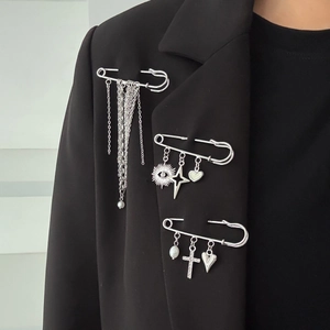 Gros plan de broches punk argentées avec étoile et pompon sur une veste de blazer