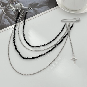 Détail de la broche punk gothique avec chaînes de perles noires et pendentif étoile