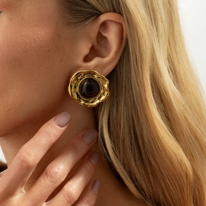 Detail of vintage gold geometric earring with hammered metal texture and tiger eye stone