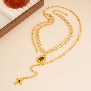 Gold layered necklace with vintage oval pendant and delicate cross charm details