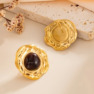 Detail of vintage gold-tone earrings with irregular wave frames and deep brown stones