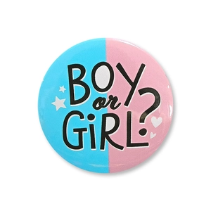 Macro detail of gender reveal tinplate button badge with Boy or Girl lettering