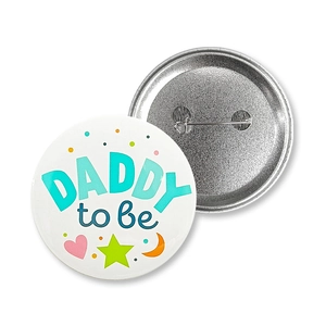 Detail of Daddy to be tinplate badge with safety pin back for gender reveal party