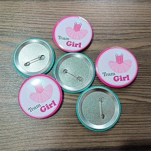 Détails macro des badges de baby shower Team Girl avec tutu rose et épingle de sécurité
