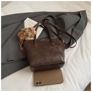 Dettaglio della borsa a secchiello marrone vintage in pelle cerata con logo impresso
