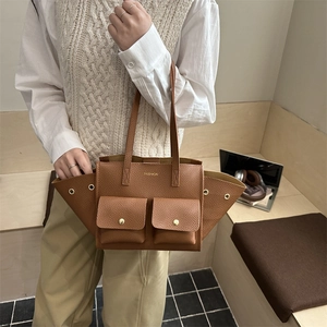 Brown lychee leather trapezoid tote bag with dual front pockets for city commuting