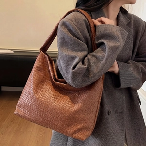 Gros plan détaillé du sac hobo en cuir tressé marron montrant la texture et la qualité