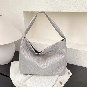 Gros plan détaillé du sac hobo tissé argenté avec texture métallique sur tweed