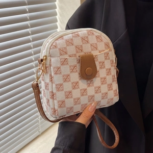 Detail of vintage crossbody phone bag with Z-pattern print and gold zipper closure
