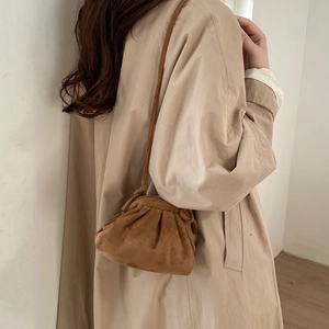Brown frosted suede pleated cloud bag worn by model over a beige trench coat