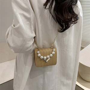Woven khaki mini crossbody bag with pearl handle and golden heart lock on model