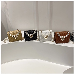 Detail view of chain crossbody bags in gold, black, white, and brown with pearl handles
