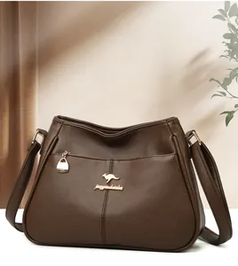 Detail of dark brown pebble leather shoulder bag with gold kangaroo logo and zipper