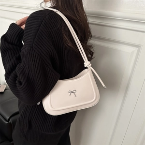 Minimalist cream white underarm bag with silver bow accent and knotted shoulder strap
