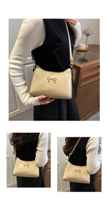 Detail view of cream leather shoulder bag showing gold bow buckle and adjustable strap