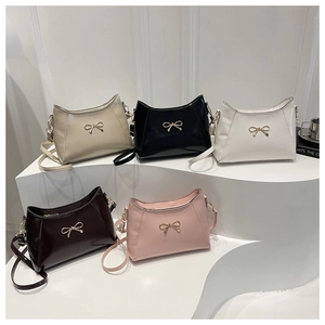 Detail showing five colors of small square handbags with bow accents and shoulder straps