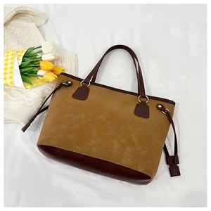 Detail view of large minimalist two-tone leather tote bag with side drawstring accents