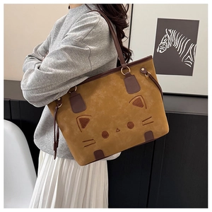 Close-up of cat embroidery and suede texture on a vintage brown tote bag for women