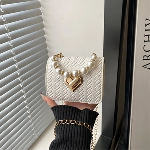 Fashionable white woven mini square bag with pearl handle and gold heart clasp detail