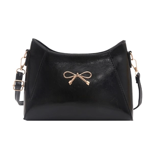 Chic black glossy leather underarm bag with golden bow ornament and adjustable strap