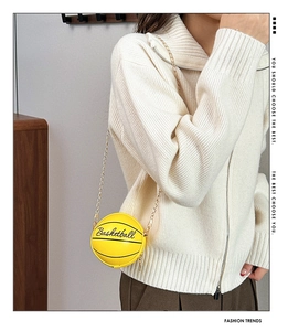 Detalle del bolso bandolera amarillo con forma de baloncesto con cadena dorada y cuero