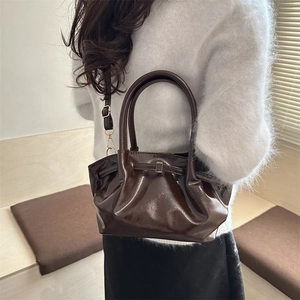 Deep brown glossy patent leather tote bag with cloud pleats and a metal buckle design