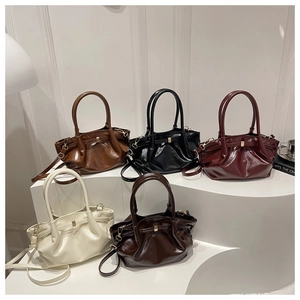 Five assorted glossy pleated bucket bags in rich colors with golden hardware details