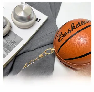Detalle de mini bolso de baloncesto con textura naranja y cadena de metal dorado
