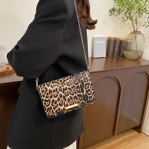 Vintage leopard print crossbody square bag with gold chain strap worn by a model