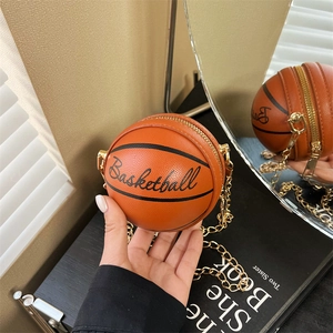 Detalle del bolso bandolera naranja con forma de baloncesto en cuero PU y cadena dorada