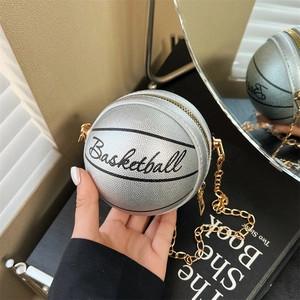 Primer plano del bolso plateado con forma de baloncesto y correa de cadena fina