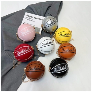 Detalle de bolsos con forma de baloncesto en varios colores con correa de cadena dorada