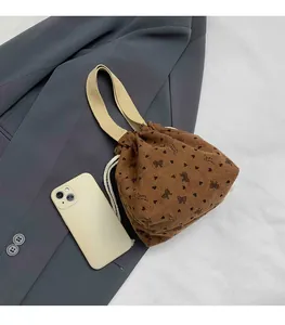 Corduroy bag size reference showing heart patterns and a phone for scale comparison