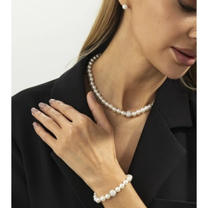 Parure de bijoux en perles élégante avec perles en strass portée sur un blazer noir chic